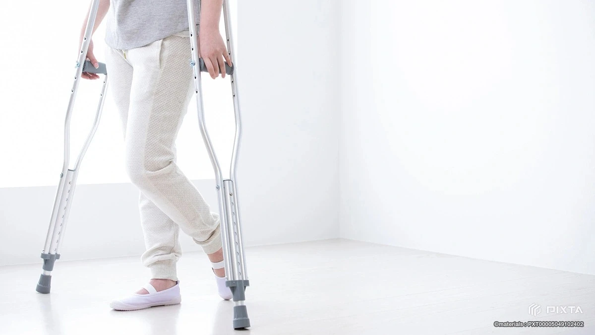 ケガからの回復をイメージした松葉杖で歩く人